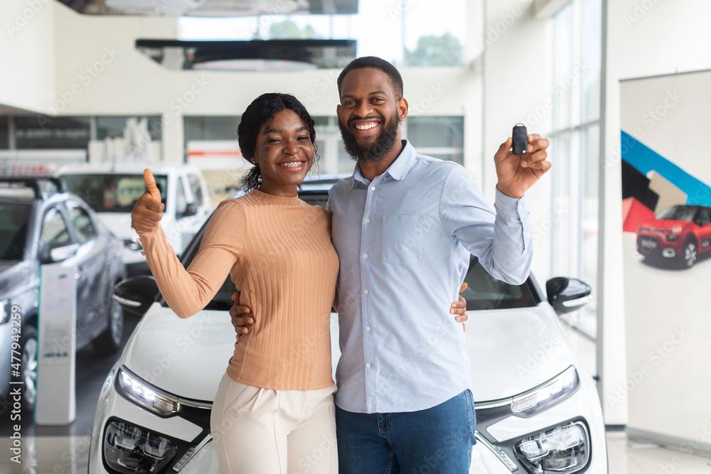 Happy Black Couple Holding Keys From New Car And Showing Thumb Up Happy Black Couple Holding Keys From New Car And Showing Thumb Up