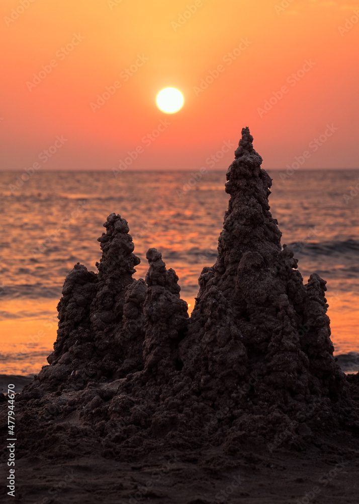 Sand castle on the sea at sunset