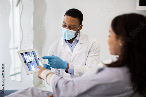 Dentist Doctor Demonstrating Female Patient Teeth Xray Picture On Digital Tablet Fototapet