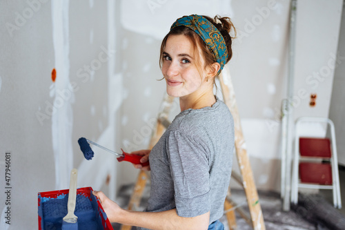 Bild auf Leinwand Happy young woman decorating the walls of her apartment