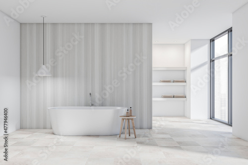 Bright bathroom interior with bathtub  wooden partition  panoramic window