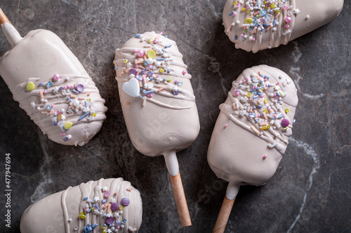 Cold and sweet popsicles with white chocolate topping
