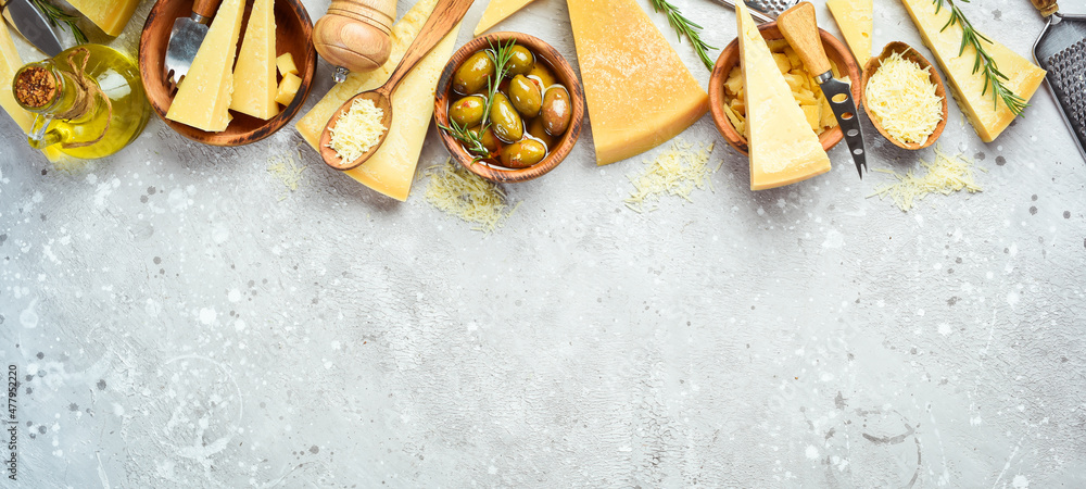 Cheese banner. Set of pieces of hard cheese. Top view. On a gray stone background. Cheese banner. Set of pieces of hard cheese. Top view. On a gray stone background.