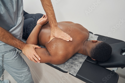 African American male patient undergoing chiropractic adjustment photo