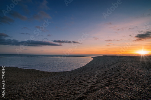 Fotografiet An aerial view of the sun setting over the coast at Shingle Street in Suffolk, U