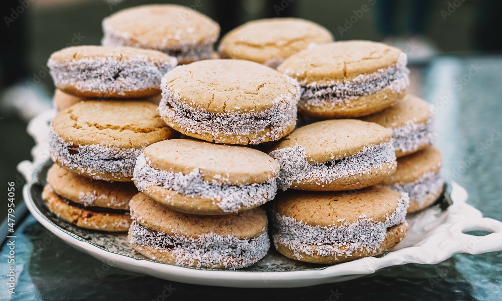 Plato lleno de alfajores de maicena rellenos de dulce de leche. Postre tipico de sudamerica Plato lleno de alfajores de maicena rellenos de dulce de leche. Postre tipico de sudamerica