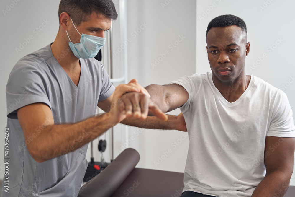 Obraz premium Patient being examined by physiotherapist during resisted isometric test