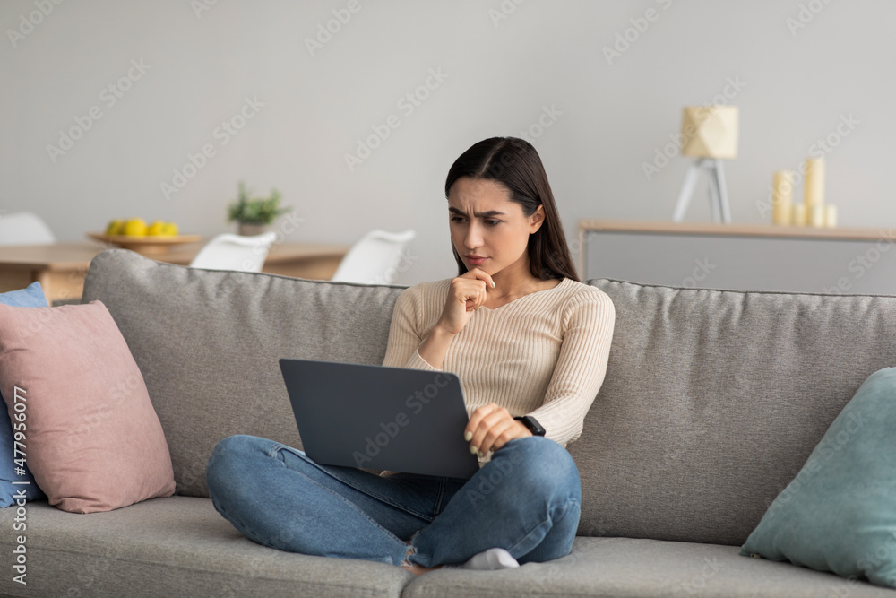 Online work, chat on social networks on computer sitting on sofa Online work, chat on social networks on computer sitting on sofa
