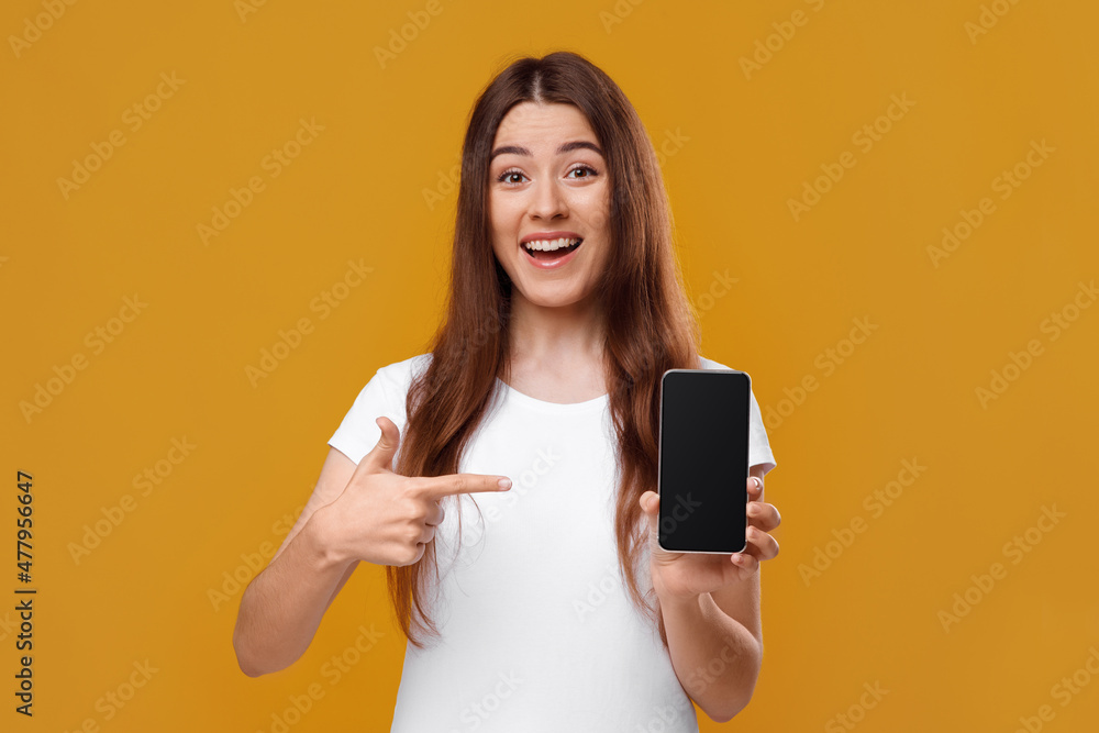 Happy young woman showing smartphone with empty screen Happy young woman showing smartphone with empty screen