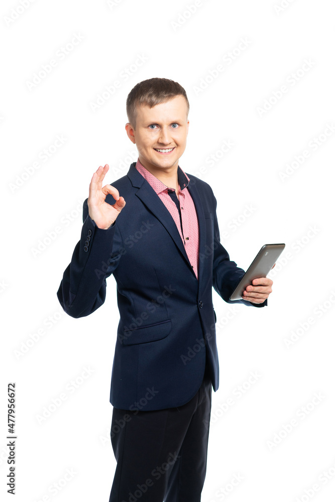 a young man in a suit and shirt holds a tablet and shows with his fingers approx. isolated a young man in a suit and shirt holds a tablet and shows with his fingers approx. isolated