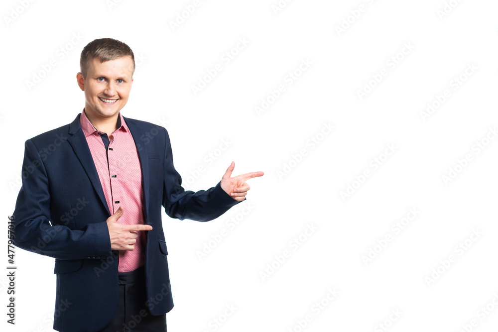 a young man in a blue jacket and pink shirt points his fingers to the side. the guy smiles and looks at us. isolated a young man in a blue jacket and pink shirt points his fingers to the side. the guy smiles and looks at us. isolated