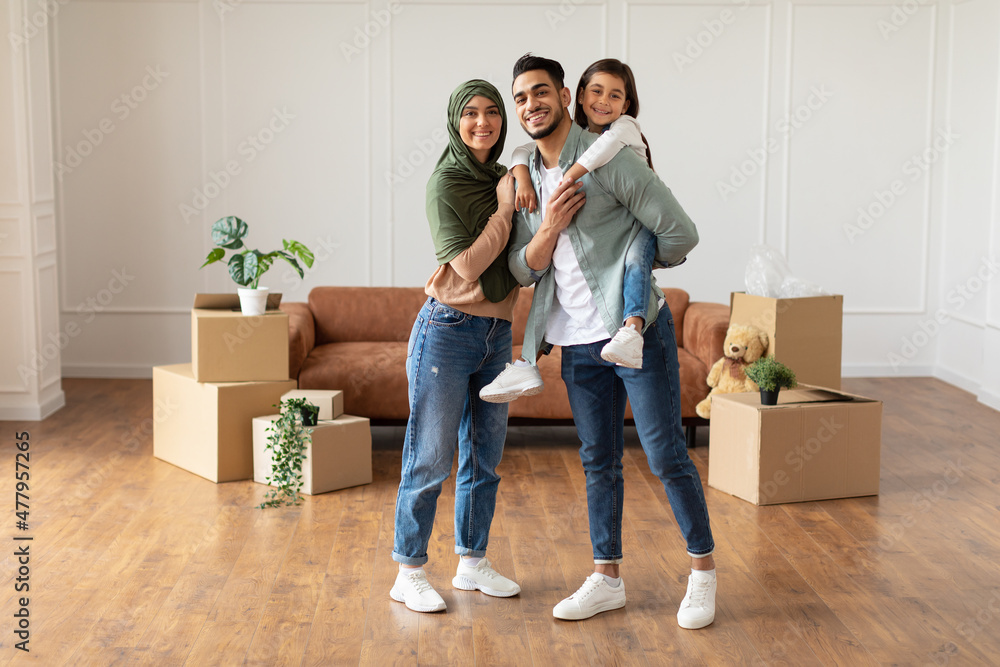 Happy muslim family looking at camera, posing on moving day Happy muslim family looking at camera, posing on moving day