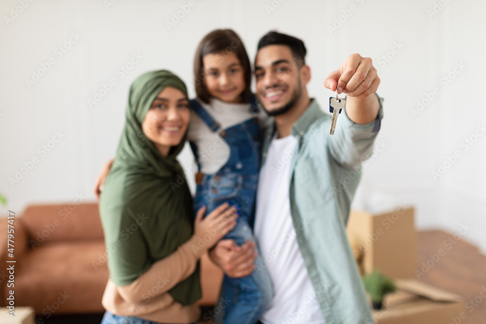 Happy middle eastern family showing keys of their apartment