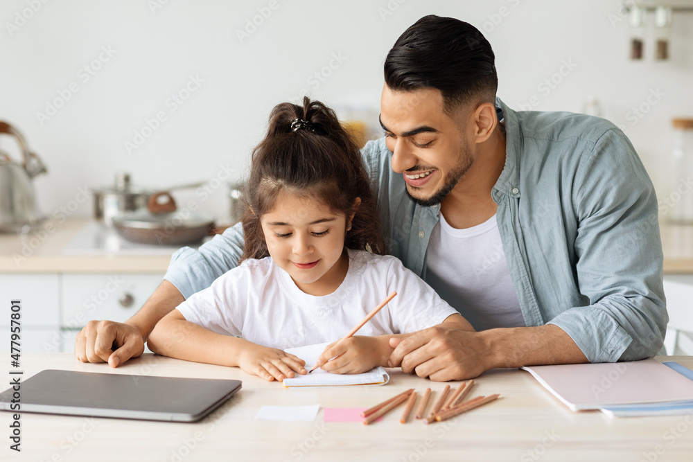 Happy father and daughter painting together, kitchen interior Happy father and daughter painting together, kitchen interior