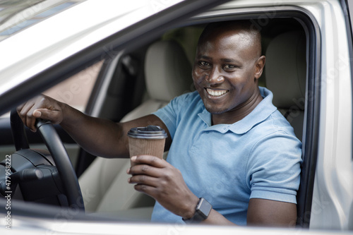 Cheerful african american man driver drinking coffee
