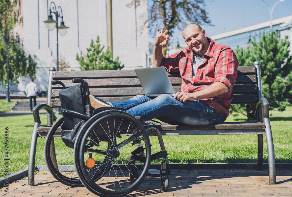 Freelancer with a physical disability who uses wheelchair working at the park Freelancer with a physical disability who uses wheelchair working at the park