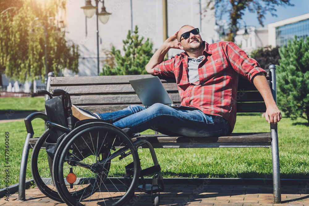 Obraz premium Freelancer with a physical disability who uses wheelchair working at the park