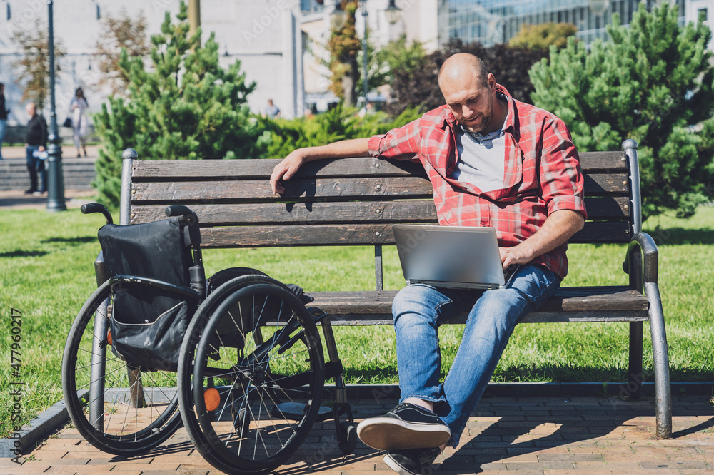 Freelancer with a physical disability who uses wheelchair working at the park Freelancer with a physical disability who uses wheelchair working at the park