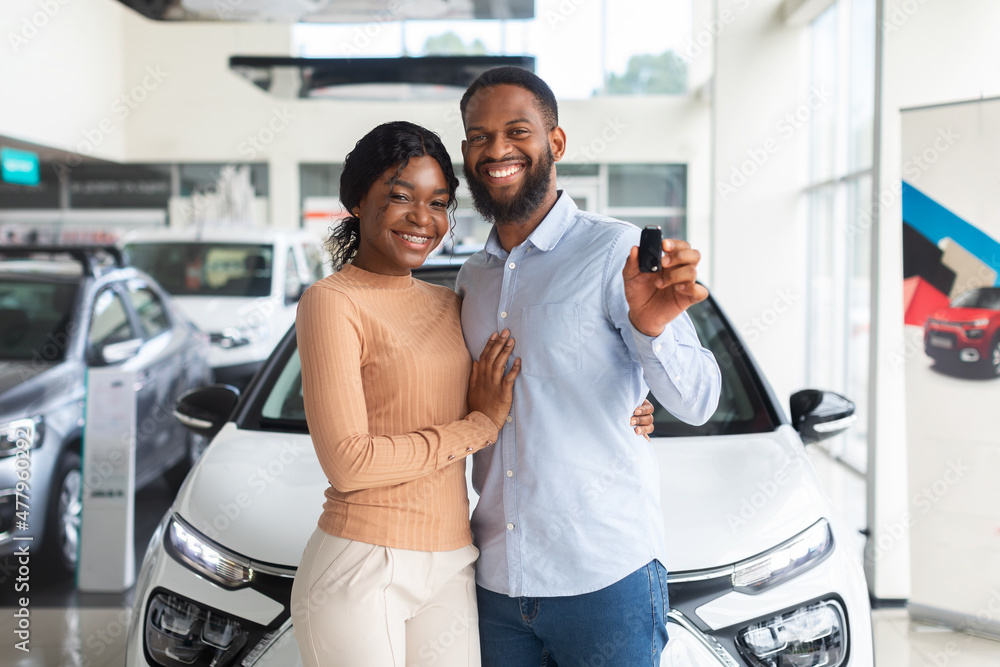Obraz Happy Owners. Cheerful Black Spouses Holding Key Of Their New Car fototapeta, plakat