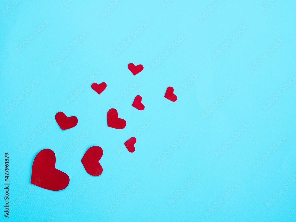 Many red hearts on a blue background. Valentine's day concept. Place for your text.
