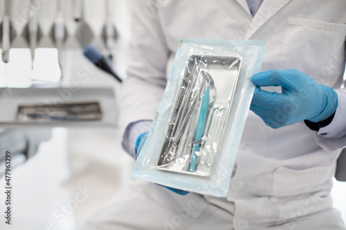 Foto Unrecognizable Dentist Doctor In Uniform Demonstating Sealed Sterilization Pouch
