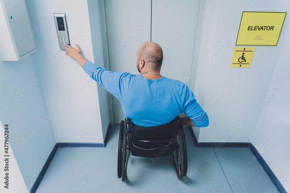 Person with a physical disability who uses wheelchair using lift in building
