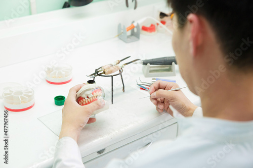 Dental technician doing partial dentures of acrylic resins in the lab. photo