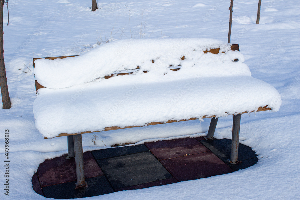 Snow covered bench in park. Winter background photo. Snow covered bench in park. Winter background photo.