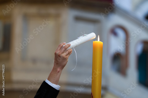 Fotografie, Obraz person holding a candle - Christening