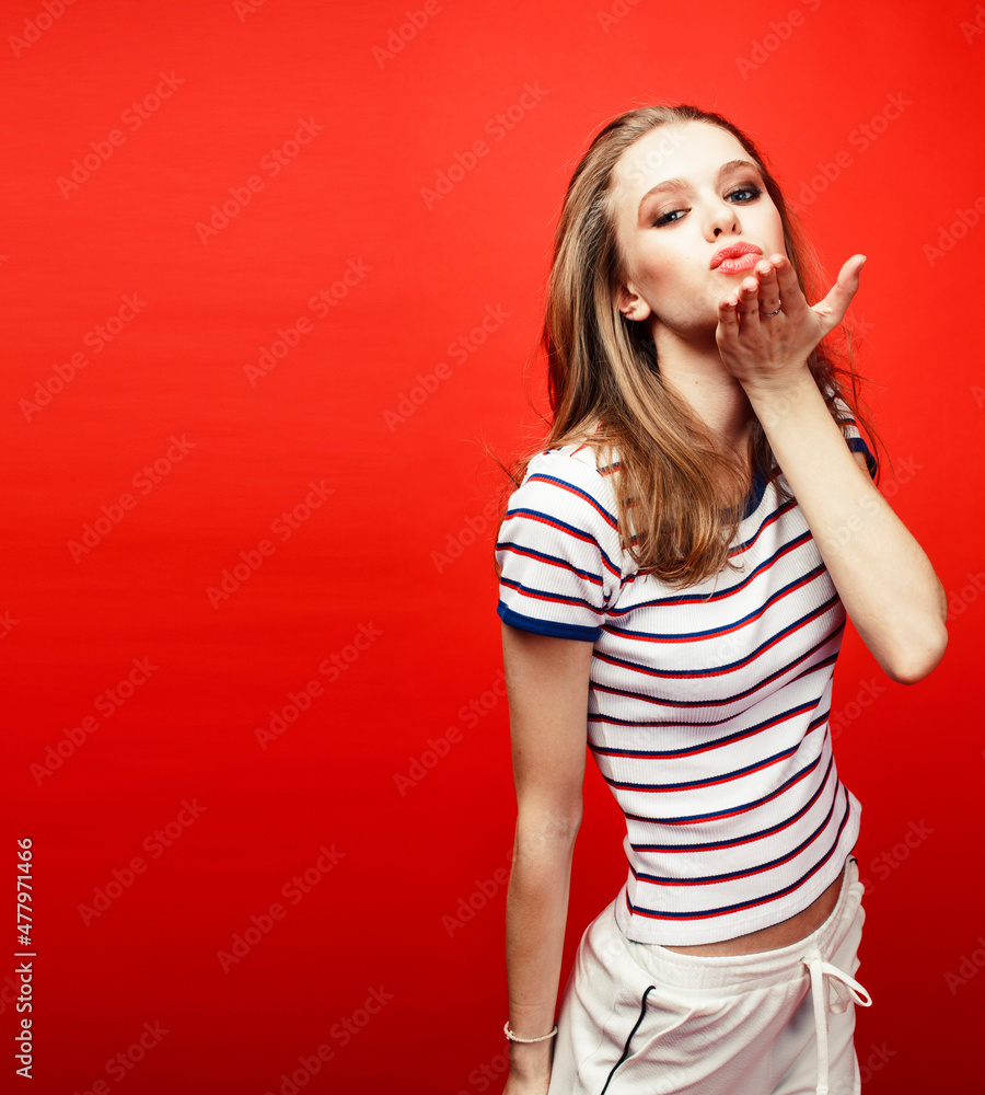 Fototapeta premium young pretty emitonal posing teenage girl on bright red background, happy smiling lifestyle people concept