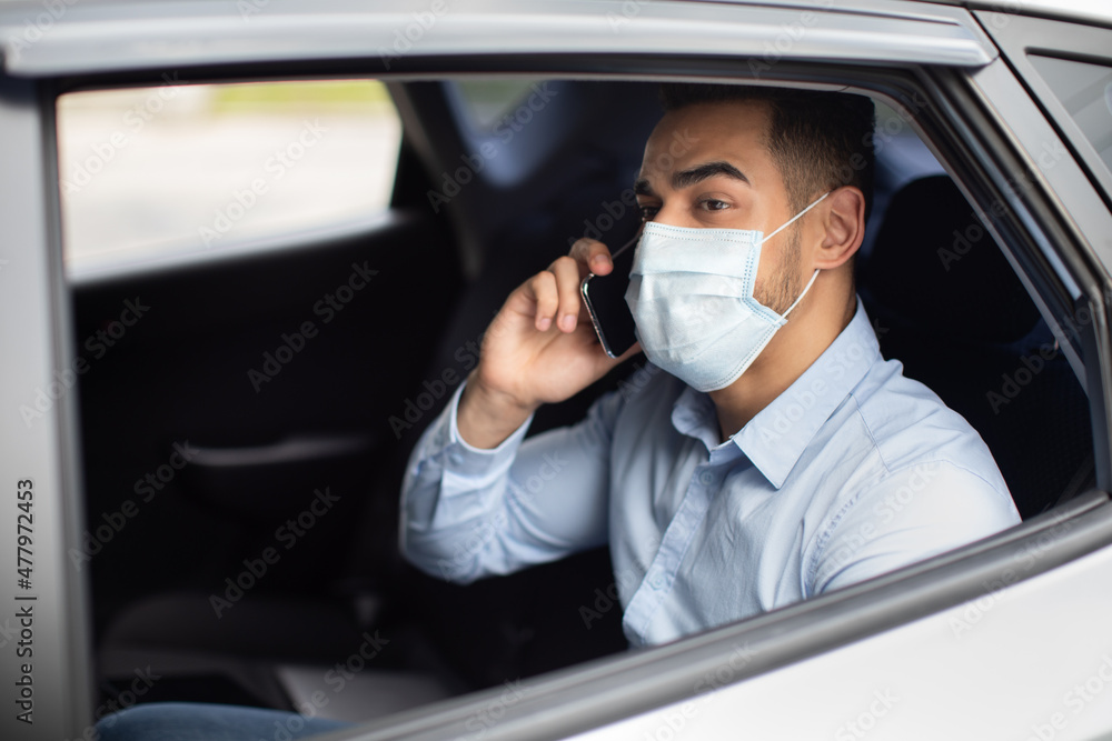 Closeup of arab businessman in face mask sitting in car