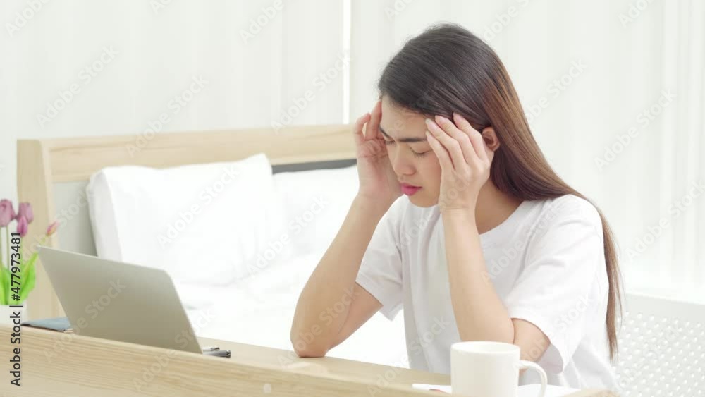 Young beautiful unhappy Asian woman work on desk in bedroom at home with pressure, typing computer laptop with stress, frown and sigh. Impact of online communication problem, social media pressure. Young beautiful unhappy Asian woman work on desk in bedroom at home with pressure, typing computer laptop with stress, frown and sigh. Impact of online communication problem, social media pressure.