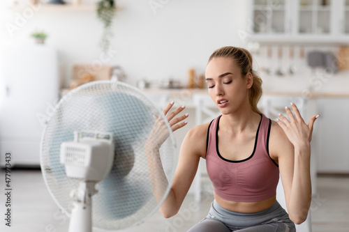 Summer heat, workout at home, breathe fresh air from floor fan, suffering from lack of conditioner
