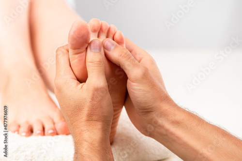The masseur gives the girl a foot massage