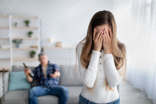 Canvas Mature woman crying, husband dinking alcohol, blaming and accusing her at home, free space