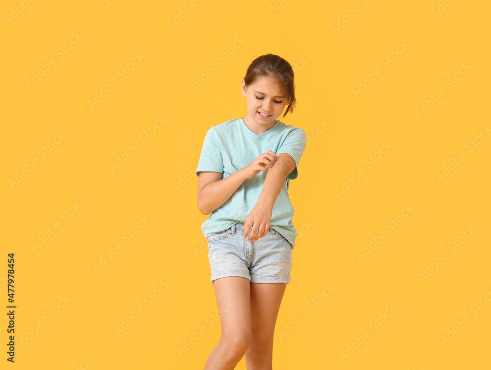 Little girl scratching herself on color background