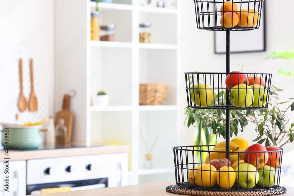 Stand with healthy fruits on counter in modern kitchen Stand with healthy fruits on counter in modern kitchen