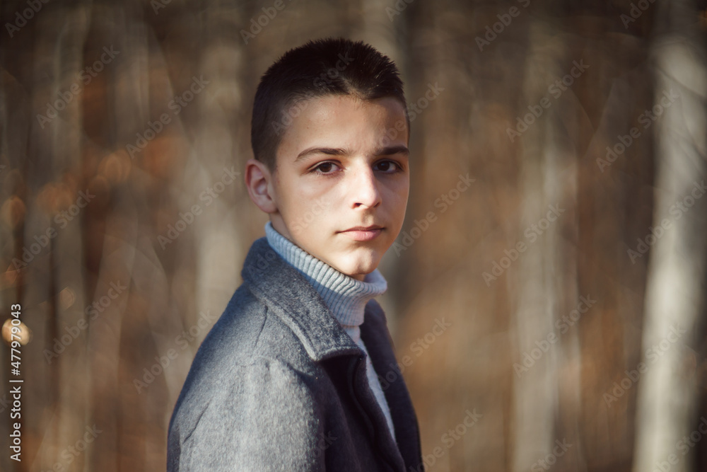 young teenager stands in the woods in late December young teenager stands in the woods in late December