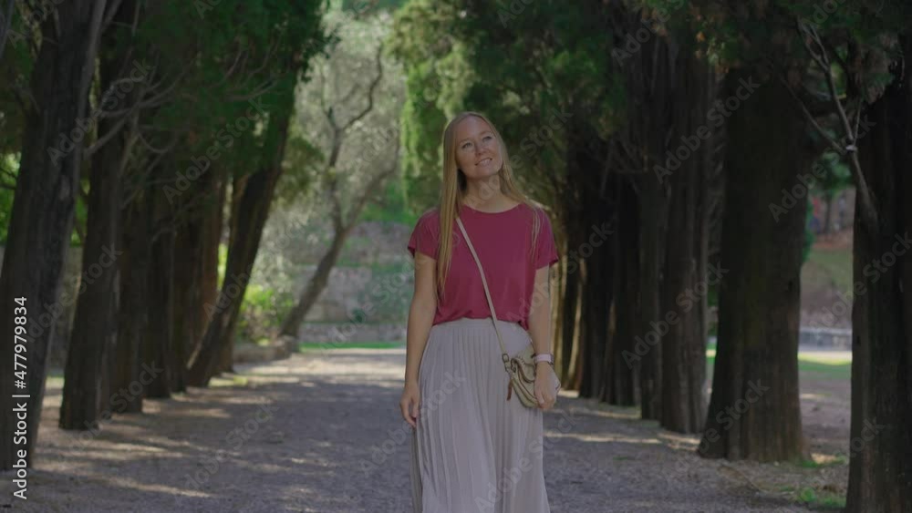 A young woman tourist walks along the valley in the Park Milocer near the city of Budva. Travel to Montenegro concept A young woman tourist walks along the valley in the Park Milocer near the city of Budva. Travel to Montenegro concept