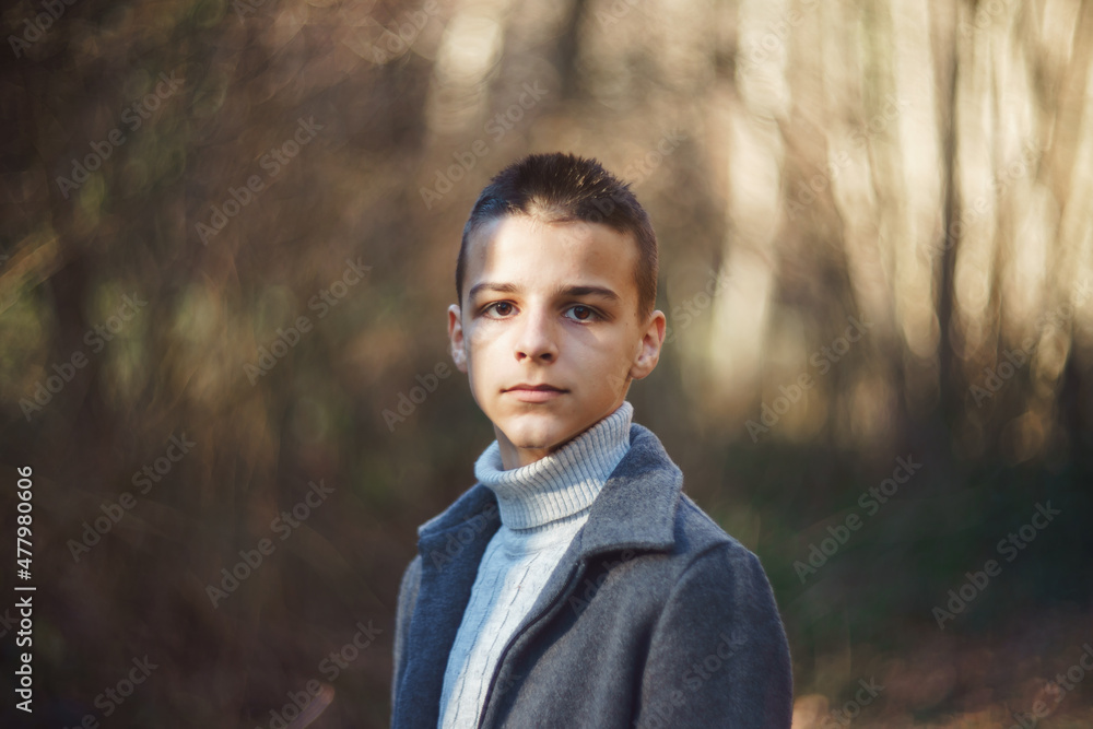 young teenager stands in the woods in late December young teenager stands in the woods in late December