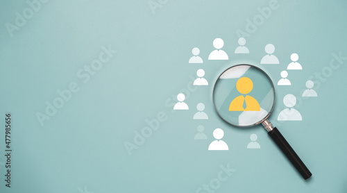 Magnifier glass focus to manager icon which is among staff icons for human development recruitment leadership and customer target group concept.
