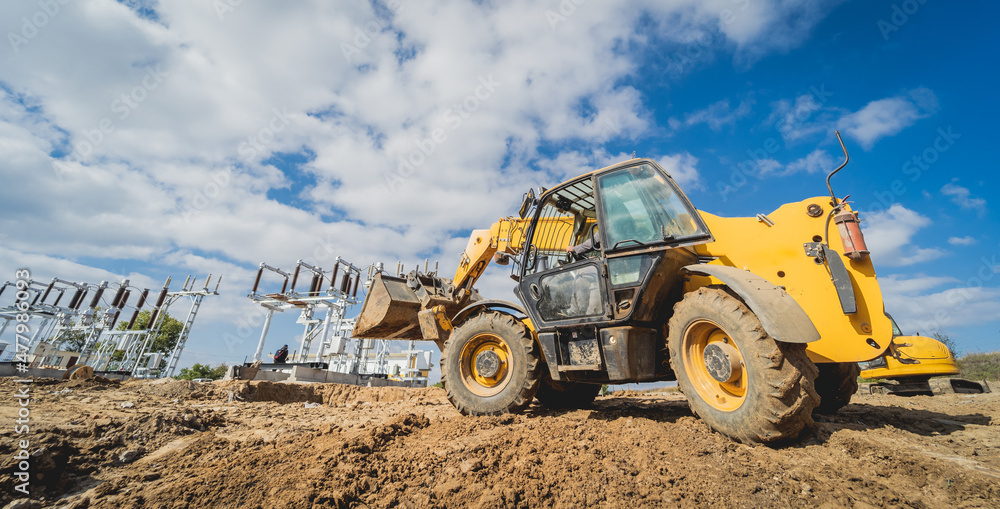 Obraz premium Wheel loader excavator works at construction site