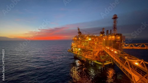 offshore oil and gas platform in sunset time the platform produced raw gases and crude oil for sent to onshore refinery, petrochemical plant and tanker for export for industry concept.