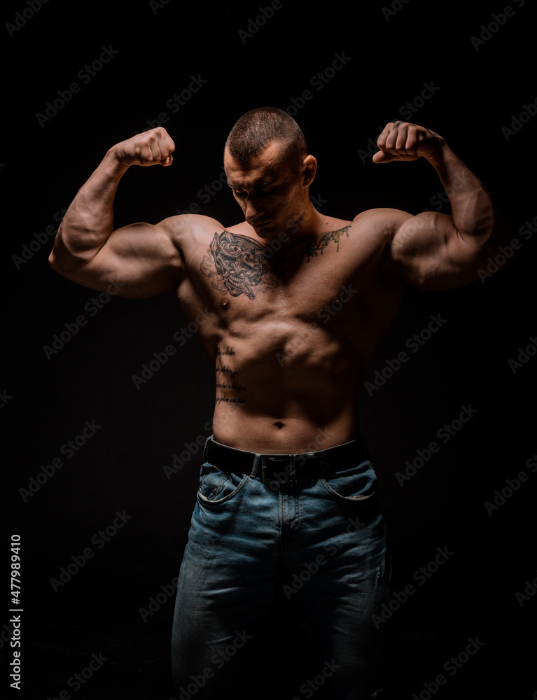 Portrait of strong man showing muscles isolated on black Portrait of strong man showing muscles isolated on black