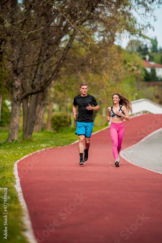 Young couple is jogging on running track in park