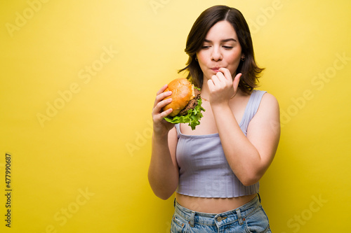 Hungry woman holding a burger