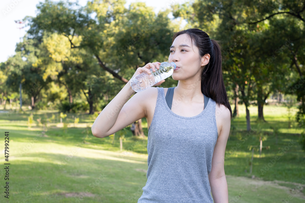 Female exercise and drink water. Beautiful girl in sportswear drinks water from a bottle during break. Young beautiful woman drinks water from a bottle in summer green park. Woman takes a break. Female exercise and drink water. Beautiful girl in sportswear drinks water from a bottle during break. Young beautiful woman drinks water from a bottle in summer green park. Woman takes a break.
