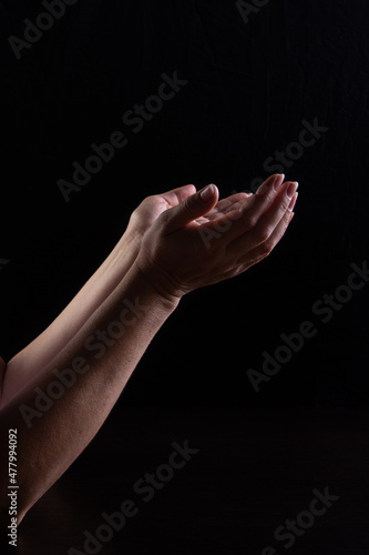 Women's hands express confusion, loss. Plea. The concept of expressing emotions with your hands. Low key. Vertical frame