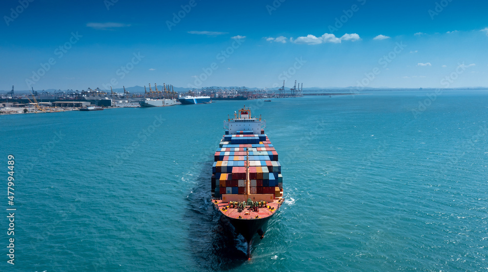 Aerial in front of cargo ship carrying container and running for export  goods  from  cargo yard port to custom ocean concept freight shipping by ship .