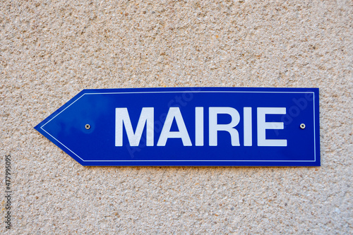 Panneau de signalisation bleu sur lequel est écrit le mot "mairie" en langue française. Gros plan